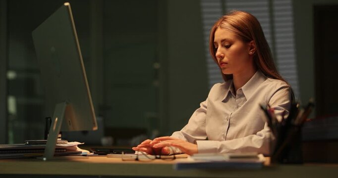 Woman makes fatal mistake working on computer at workplace. Female secretary deletes important business data overworking at stormy night