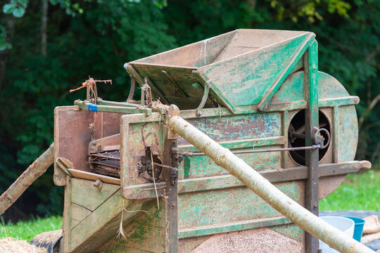 Vintage wheat threshing machine in rustic setting