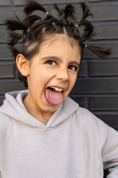 Young boy with creative pigtails making a funny face