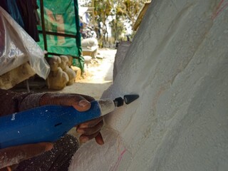 Sculptor carving an Styrofoam sculpture

