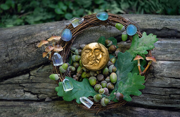 symboling moon amulet, minerals, acorns, oak leaves on tree trunk, natural background. forest...