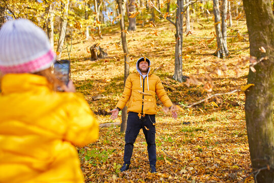 Father and Daughter Enjoying a Colorful Autumn Day in the Park While Playing With Fallen Leaves