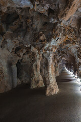Explore the intricate details of a narrow cave tunnel in Sintra, Portugal, featuring rugged rock formations and dramatic lighting that highlights its natural beauty.
