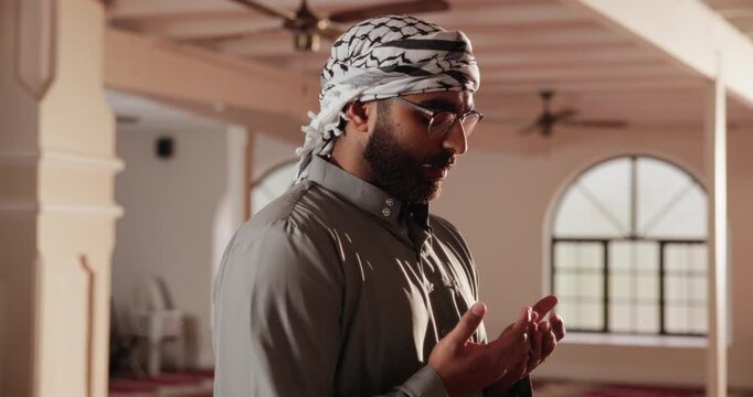 Muslim, man and imam in mosque for prayer, intention and faith in religion. Islamic, male person and open hands in temple for spiritual healing, praise and peace in place of worship in Saudi Arabia