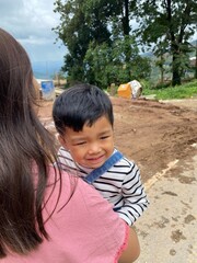 Mother and son enjoying a sunny day at the park, smiling and having fun togethe