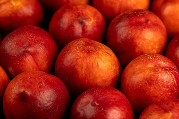 a large number of ripe soft nectarine fruits on the table
