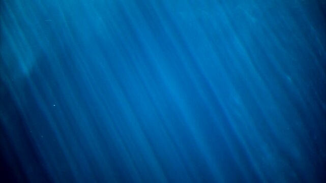 Sun rays under blue water, close up shot