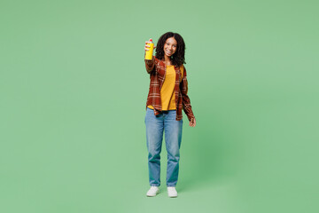 Full body young artist teen girl student she wear brown yellow casual clothes backpack bag hold books paint graffiti mural isolated on plain green background. High school university college concept. © ViDi Studio