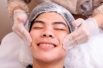 Rubbing in hyaluronic acid serum prior to a high frequency facial treatment at a spa.