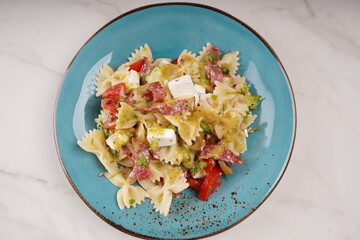 Italian pasta salad cucumbers, cherry tomatoes, olives, red onion,  salami, feta cheese