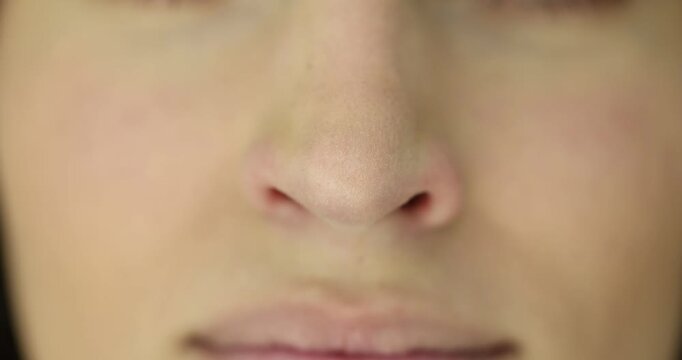 Woman wrinkles nose experiencing itching caused by allergies. Female feels irritation trying to relief discomfort with facial movements