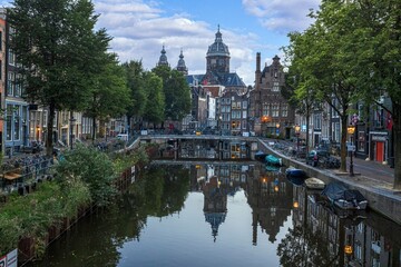 Image of St Nicholas Basilica in Amsterdam with adjacent canal in summer 2023