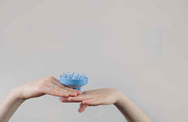 Silicone Exfoliator Massager brush for circulation and follicle stimulation for optimal scalp health in woman hand. Silicone Scrubber in bathroom.