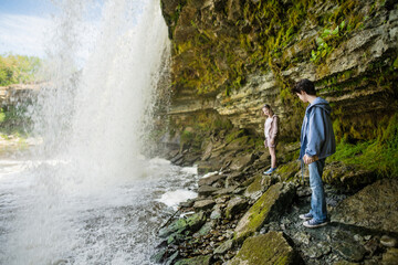Naklejka premium Teenage girls admiring Jagala Waterfall or Jagala juga, the widest natural waterfall in Estonia, located on the Jagala River near the Gulf of Finland. Koogi, Harju County.