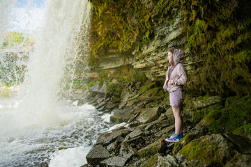 Teenage girl admiring Jagala Waterfall or Jagala juga, the widest natural waterfall in Estonia, located on the Jagala River near the Gulf of Finland. Koogi, Harju County.