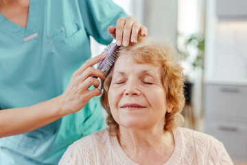 Nurse brushing hair of relaxed senior woman at home