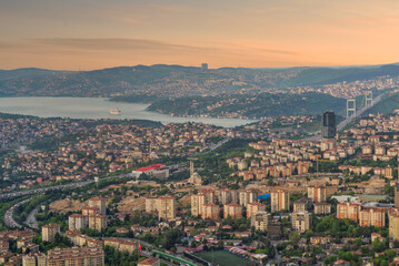 Obraz premium The urban skyline of Istanbul, Turkey is captured at sunset, showcasing sprawling neighborhoods, the Bosphorus Strait, and distant hills