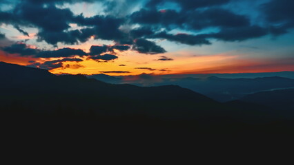 Witness the stunning transition of day to night in the Carpathian mountains as vibrant colors fill the sky during a breathtaking sunset.