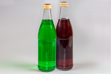 Green and red non-alcoholic carbonated drink in glass bottles