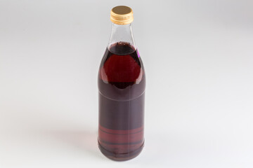 Red non-alcoholic carbonated drink in the closed glass bottle