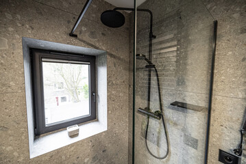 Modern bathroom with floor. sink, toilet and shower. Interior of a modern bathroom featuring sleek tile walls and concrete floor design. Interior of a modern bathroom with tile walls and concrete.