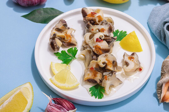 Pickled rapan meat with oil, spices and greens. Healthy seafood rich of omega
