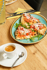 Slices of bruschetta with tomato, salad and parmesan cheese at a restaurant