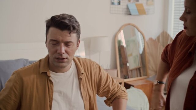 Medium shot of father trying to calm his wife and teenage son down when having family quarrel at home