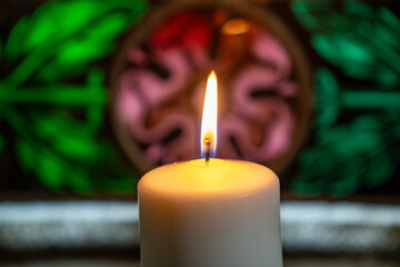 One candle flame at night in church closeup - isolated, macro.