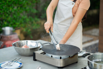 Portrait of a woman cooking in the garden.