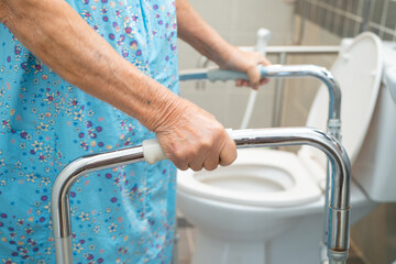 Asian elderly woman patient use walker and toilet bathroom handle security in nursing hospital,...