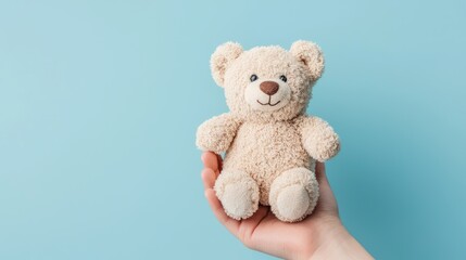 Obraz premium Comforting Childhood Memories - Hand Holding Small Teddy Bear Against Soft Blue Background, Generative Ai