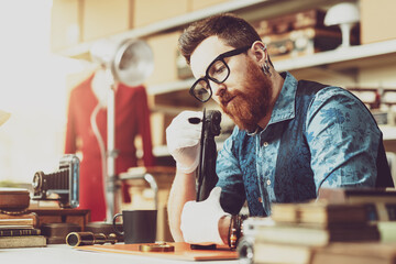 Antique dealer cleaning an old scupture in his shop