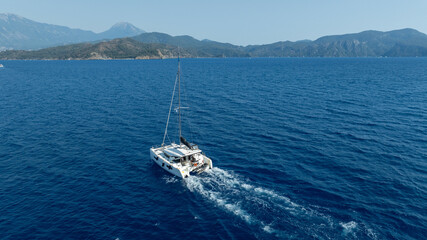  catamaran sailing gracefully, captured by a drone.