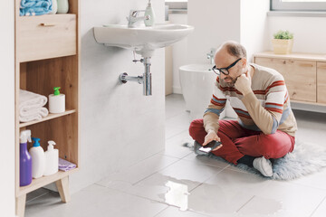 Sad man looking at a water leak