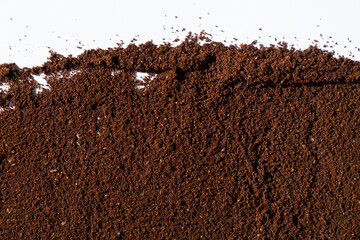 Scattered ground natural coffee on white background, top view.