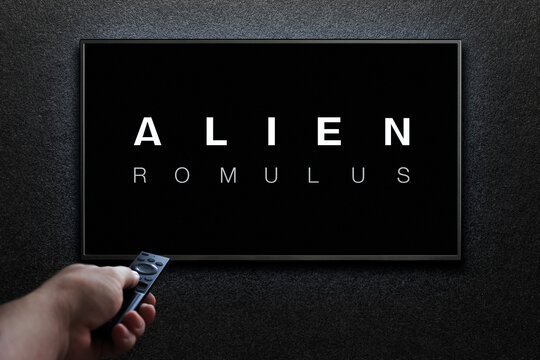 Alien Romulus trailer or movie on TV screen. Man turns on TV with remote control. Astana, Kazakhstan - July 31, 2024.