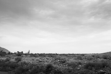 A road trip landscape in which you can see the rocky desert and a mosque with its minaret typical of Morocco, in North Africa