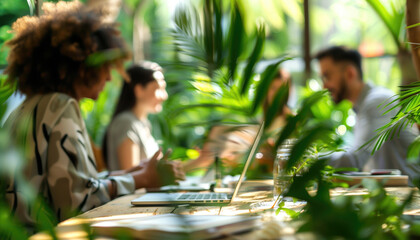 Diverse team working on laptops in a lush green environment surrounded by plants. Concepts of workplace, nature, and sustainability.
