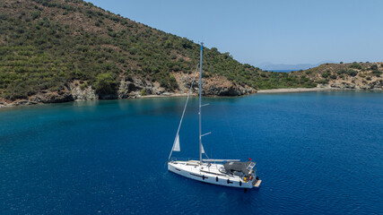 Stunning drone shot of a sailing boat gliding under the clear blue sky