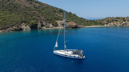 Stunning drone shot of a sailing boat gliding under the clear blue sky