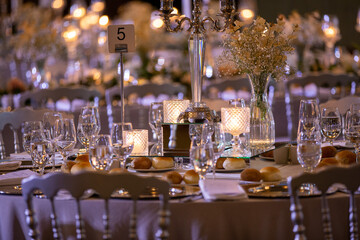 Elegant Wedding Reception Table with Floral Centerpieces, Candlelight, and Classic White Chairs for a Romantic Ambiance