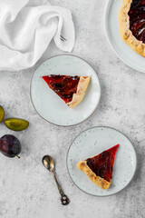 Homemade Galette with plum and honey on a light background. Summer pastry. Shortcrust dough. Zwetschgenkuchen.