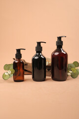 Amber Glass Pump Bottles with Greenery on Beige Background for Skincare and Beauty Products