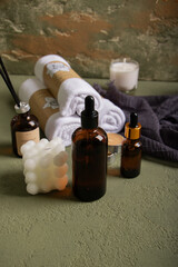 Spa Essentials and Amber Bottles on Surface with Towels and Candle