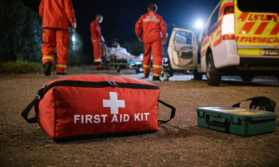 Fototapeta premium a first aid kit placed on the ground, with paramedics and an emergency team