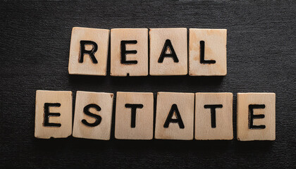 Fototapeta premium REAL ESTATE text made of wooden letters on black background. Sale and rent property concept.