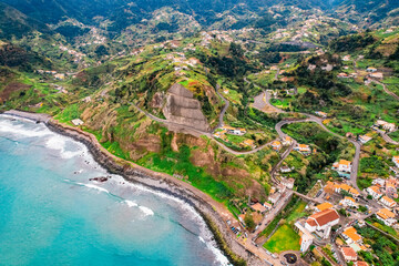 Obraz premium Aerial view of rough ocean with waves, volcanic beach in Porto da Cruz, Madeira, Portugal