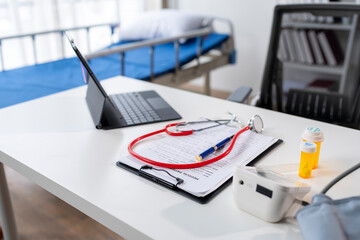 A doctor's office with a laptop, stethoscope, and a clipboard
