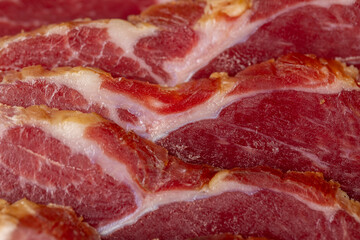 a piece of cured pork ham with thin layers of lard on the table